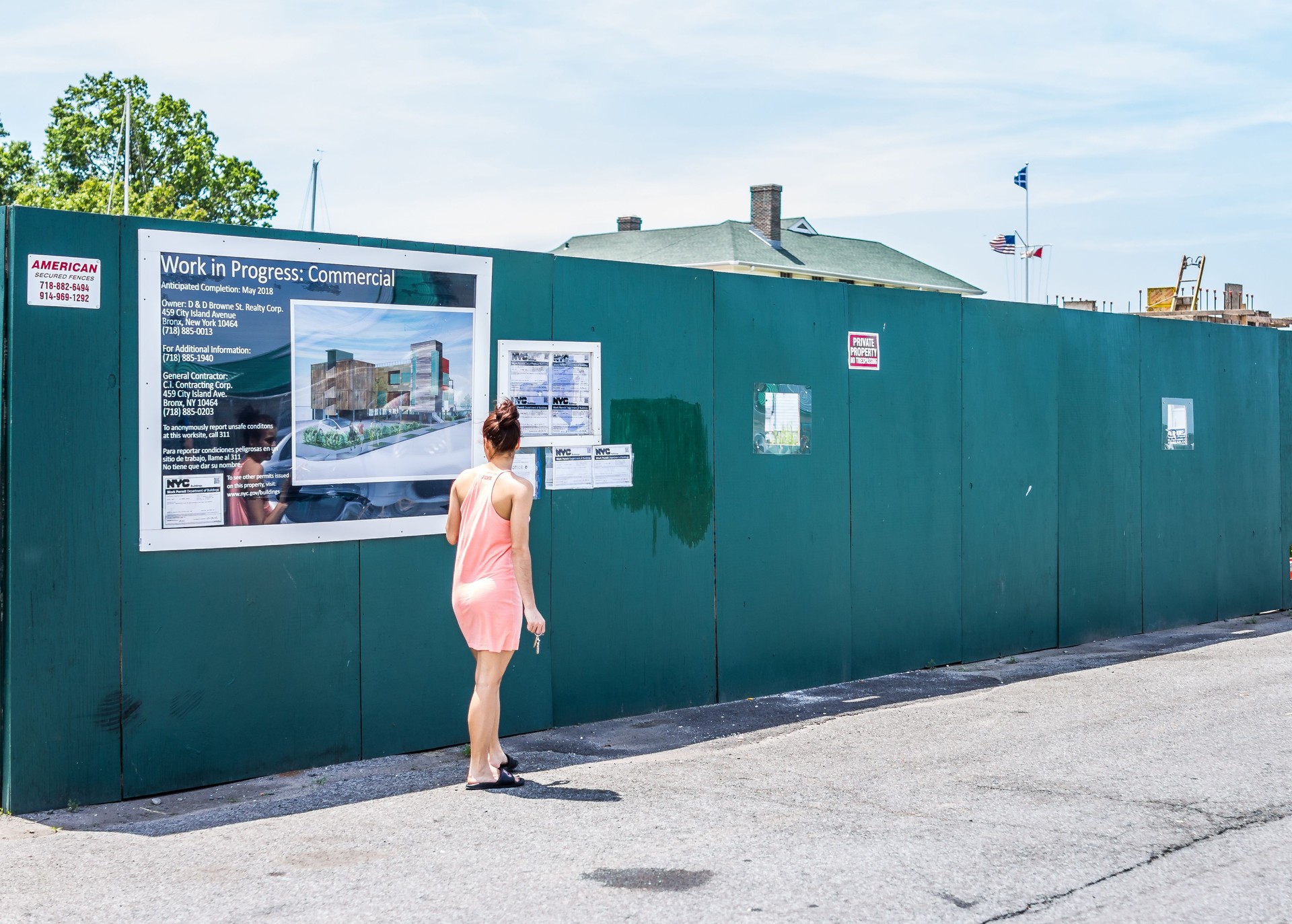 City Island road with signs of new construction and young woman reading